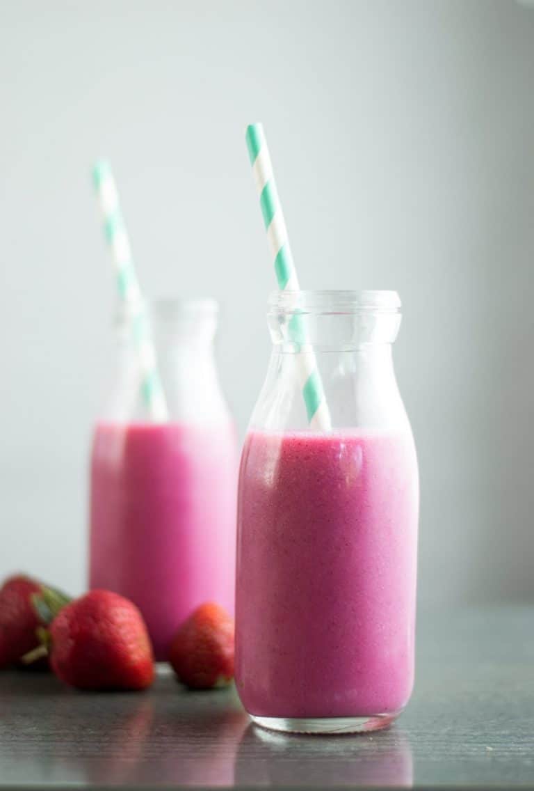 two bottles of dragon fruit smoothie with striped straws